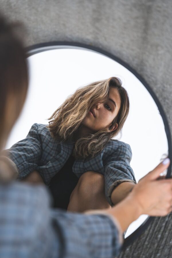 a woman looking at a mirror